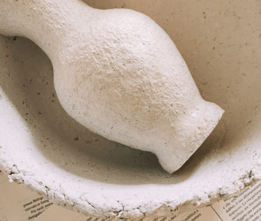 a white ceramic bird in a bowl on a table