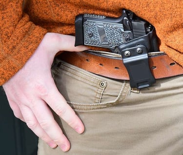 gun being concealed inside the waist band of a pair of pants