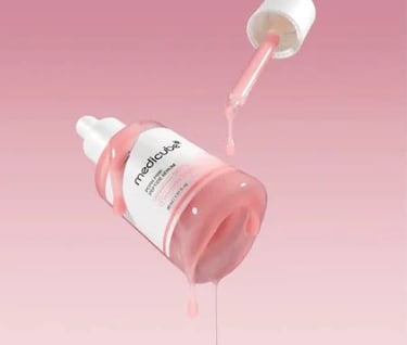 a bottle of pink liquid with a dropper in it