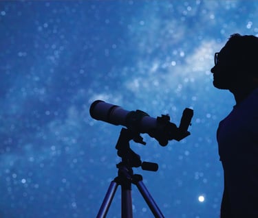 a man standing in front of a telescope