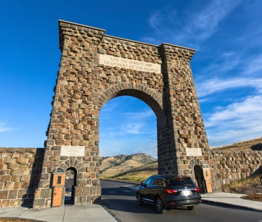 a car driving through a stone arch