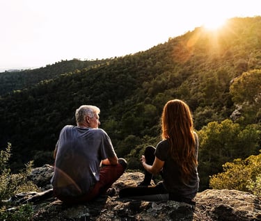 a man and woman sitting on a rock
