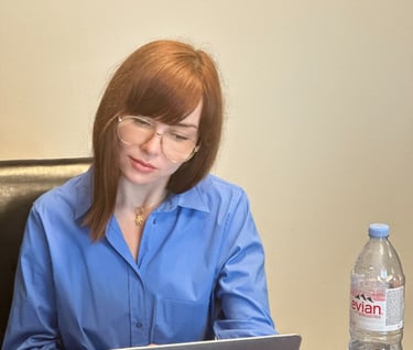 a woman sitting at a table with a laptop computer