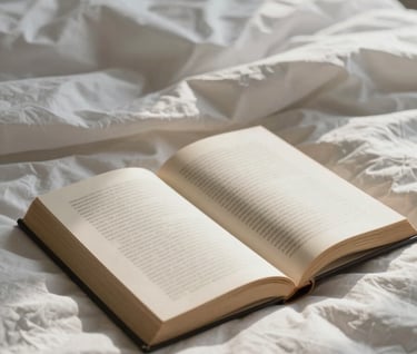 A detail shot of an unmade bed with a book left open. Natural morning light, soft shadows, film aesthetic. Colors: #F8F3EC, #8C735F.