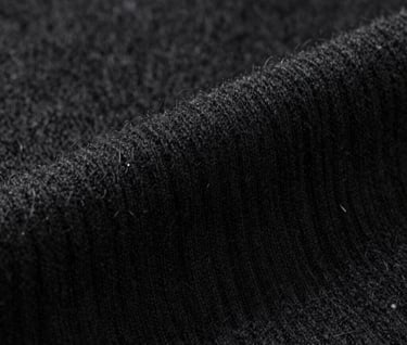 Close-up detail of high-quality black cashmere texture, soft studio lighting highlighting the artistic craftsmanship, #0F0F0F palette, sleek and sophisticated.
