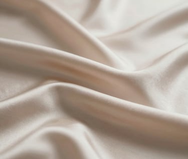 A sequence of video frames showing the ripple of silk fabric in motion. The lighting is harsh and dramatic, highlighting the texture and sheen of the material. Colors focus on #F8F4ED and #D5BFB3 for a luxurious, warm feel.