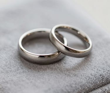 An artistic close-up of wedding rings placed on a velvet surface, showcasing timeless photography and professional detail, featuring the #F5F2F0 and #3A3335 palette.