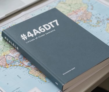 A close-up of high-quality analytical journals and printed geopolitical maps neatly stacked on a desk. The palette is muted and professional, using #4A6D7C and #F5F8FA. The composition emphasizes a lifetime of rigorous research and intellectual authority.