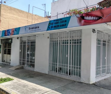 Exterior de la clínica dental Dentara con señalización profesional y rejas de seguridad en una calle