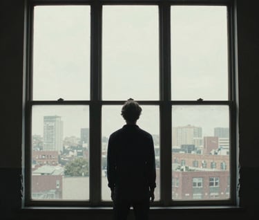 A dramatic movie poster style image featuring a silhouette of a person against a bright window in a North American / US loft, with heavy grain and a deep charcoal atmosphere.