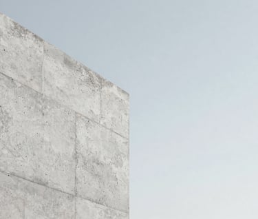 A close-up detail of architectural concrete against a clear, pale sky. The texture of the stone is highly detailed. Minimalist and refined mood, using #F5F7FA and #D0D5DB color palette.