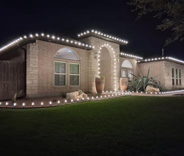 Corpus Christi house decorated with white LED Christmas roofline and walkway lights at night.