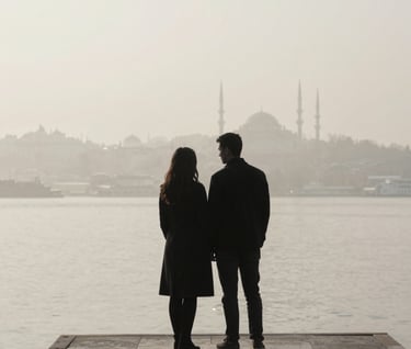 A minimalist photography shot of a couple in a charcoal black silhouette against a foggy soft off-white pier in Istanbul. Serene and luxurious atmosphere, high-end editorial style.