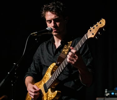 A dramatic, moody portrait of a musician in a North American performance space. High-contrast lighting with deep shadows in a chiaroscuro style. Tones of deep black and shimmering gold highlights on the instrument.