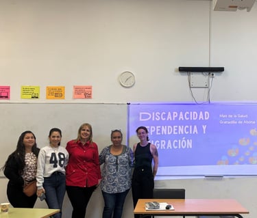 un grupo de personas posando al lado de una presentación en un taller