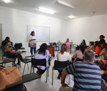 una mujer de camiseta blanca dando un taller a una clase
