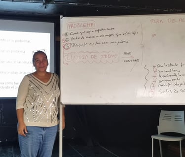 una mujer africana posando al lado de una pizarra