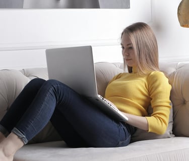 Businesswoman writing on PC on a couch