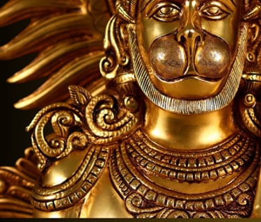 a brass statue of a hanuman with a sword