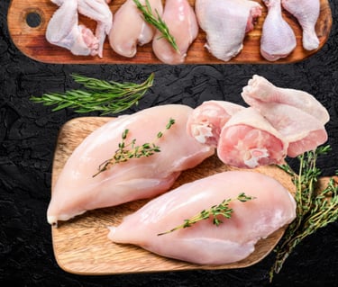 Poulet halal cru : filets, cuisses et morceaux avec herbes fraîches sur planche.