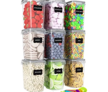 Set of nine clear airtight food storage containers with black chalkboard labels for pantry organization.