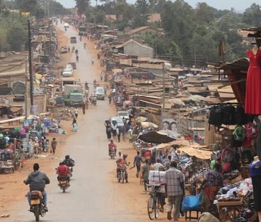 Drukke straatmarkt met mensen en motoren in West-Afrika