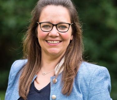 Woman wearing glasses and a blue jacket at a film production company