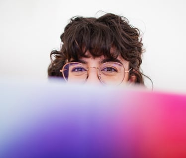 Fotografía de Blanca trabajando en su estudio tapada con un libro sobre paletas de color