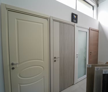 Showroom display of modern interior doors in various styles including wood grain and frosted glass designs.