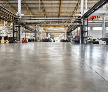 Spacious industrial warehouse with polished concrete floors and high steel ceilings.