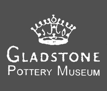 Gladstone Pottery Museum logo featuring a white crown symbol above serif text on a dark gray background.