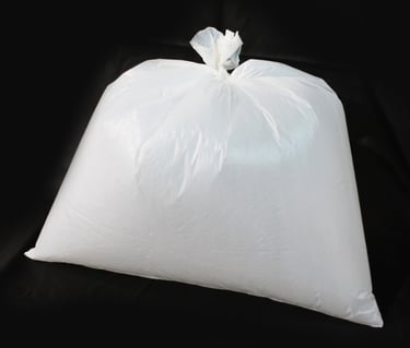 Saco para lixo branco no fundo preto.