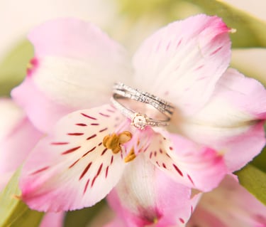a wedding ring with a diamond ring on top of a flower