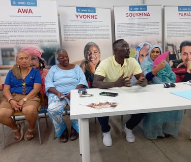 un grupo de personas migantes sentadas en una mesa en un encuentro