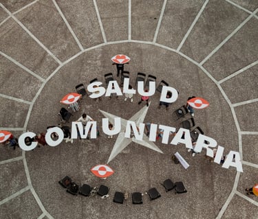 un grupo de personas de pie sujetando letras que conforman las palabras salud comunitaria
