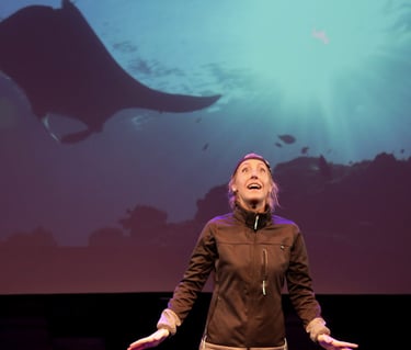 Julia Duchaussoy sur scène avec une raie Manta en arrière plan