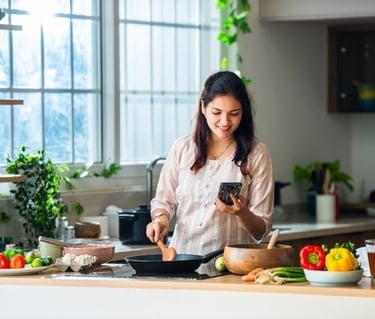 a woman is cooking in a kitchen with a phone