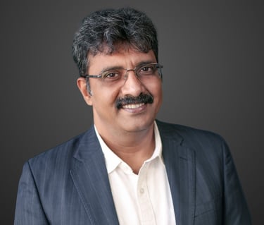 a man in a suit and glasses smiling