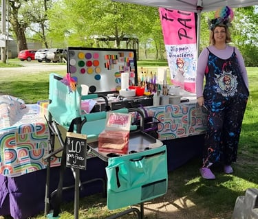 Sarah Kipper standing in front of her service table, "face painting" sign in the back