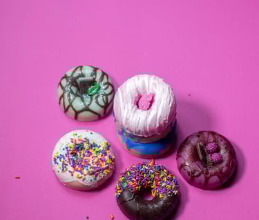 a variety of donuts made of soap and donuts on a pink background