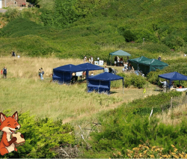Overview of marquees and people at the wildlife fair with cartoon fox eating a sandwich