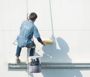 a man is painting a wall with a paint roller