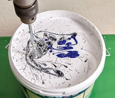 a person using a drillet to paint a bucket