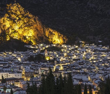 Vista aérea noturna del pueblo de Ubrique con la pena iluminada al fondo, Cádiz