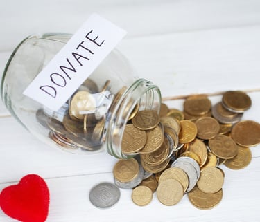 Donation jar filled with coins for supporting Auckland International Film Club events.