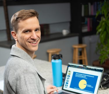 Remy sitting in a coffee shop working at their laptop, but turned to smile at you
