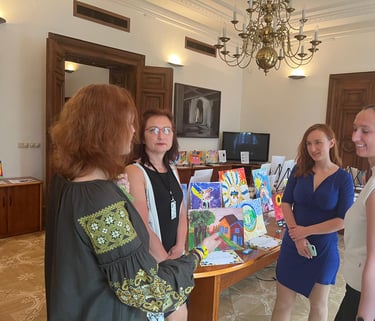 People discussing the exhibit of paintings by kids displaced by war