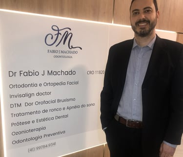 Dr. Fábio, dentista da FJM Odontologia em Curitiba, em foto profissional que destaca sua autoridade.