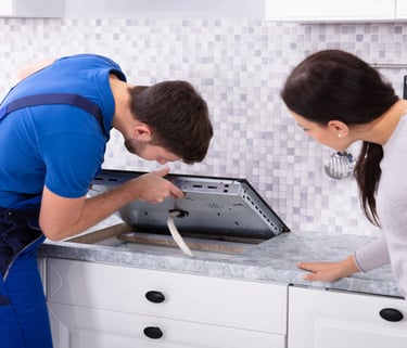 a man and woman in a kitchen with a stove top
