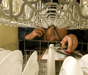 a man in a kitchen with a dishwasher and a dishwasher